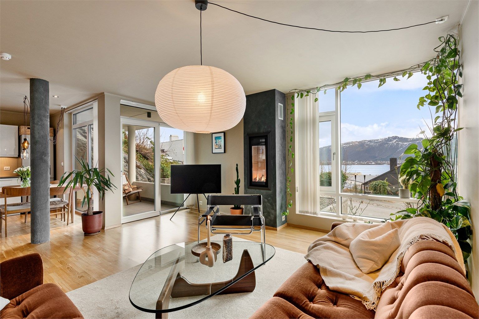 Luftig og lys stue med store vindusflater. Gasspeis og dør til terrassen 