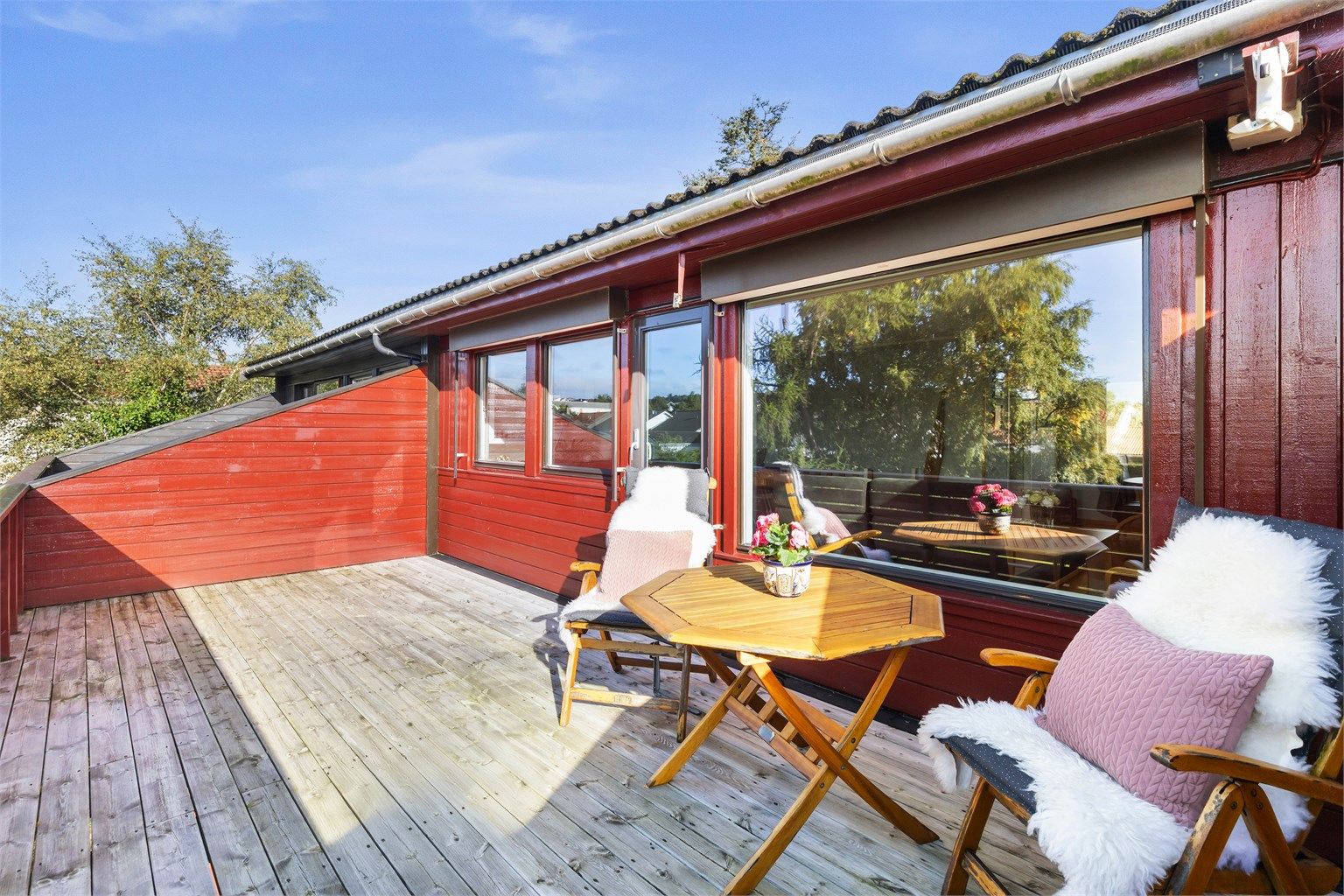 Balkong i trekonstruksjon med utgang fra stuen og god plass til utemøbler.