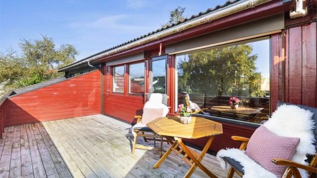 Balkong i trekonstruksjon med utgang fra stuen og god plass til utemøbler.