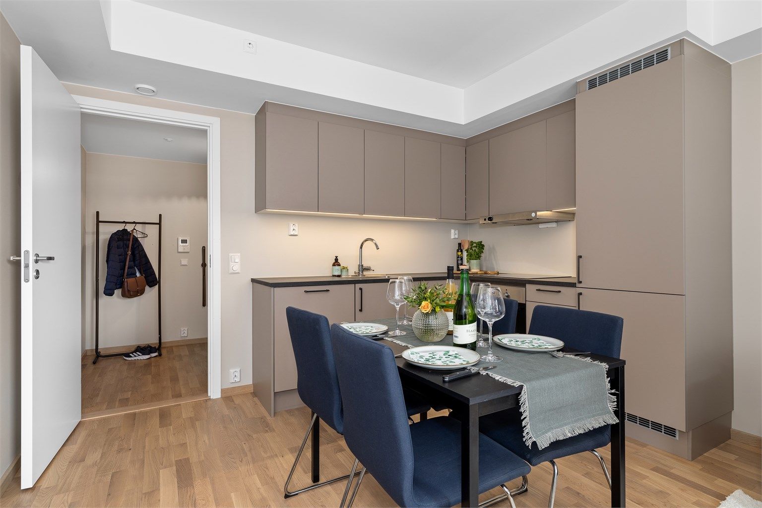 Kjøkkenet fremstår stilrent og moderne, og byr på gode oppbevaringsmuligheter i skap samt rikelig med benkeplass.