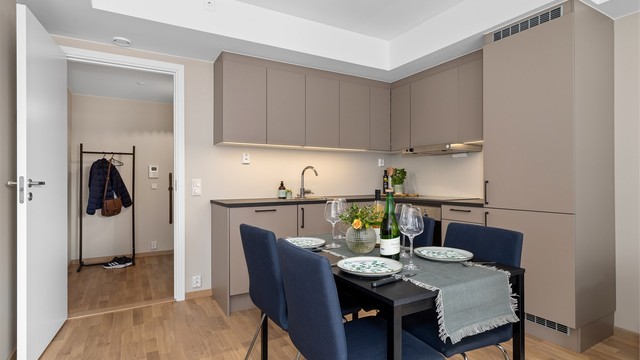 Kjøkkenet fremstår stilrent og moderne, og byr på gode oppbevaringsmuligheter i skap samt rikelig med benkeplass.