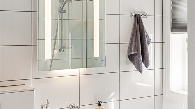 Tidløst innredet bad med flislagte gulv og vegger
