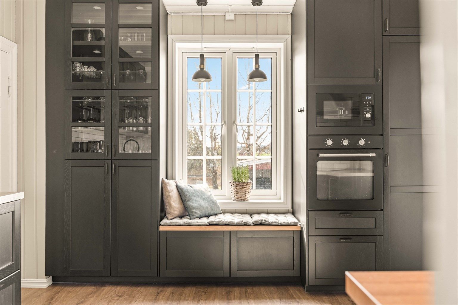 Stilrent kjøkken fra 2021 med profilerte fronter, integrerte hvitevarer og praktiske løsninger. Hyggelig sittebenk ved vinduet, god skapplass og adkomst til innvendig bod/spiskammers.