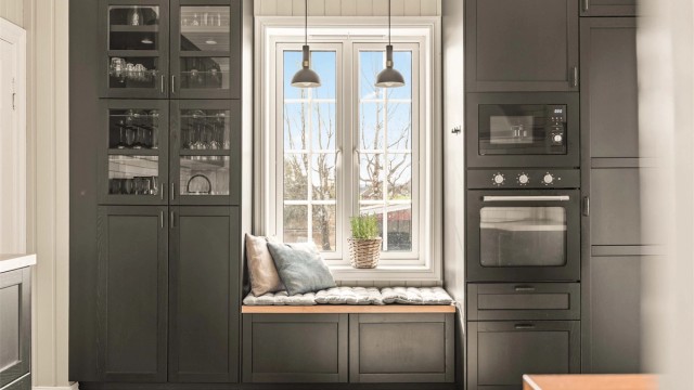 Stilrent kjøkken fra 2021 med profilerte fronter, integrerte hvitevarer og praktiske løsninger. Hyggelig sittebenk ved vinduet, god skapplass og adkomst til innvendig bod/spiskammers.