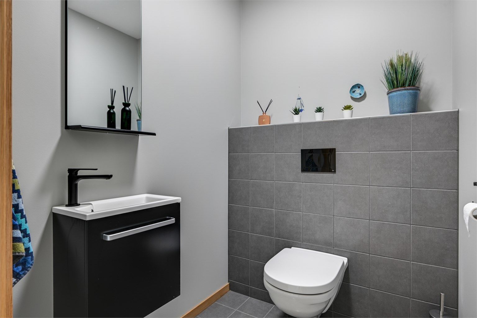 Praktisk toalettrom innredet med servant og toalett. 