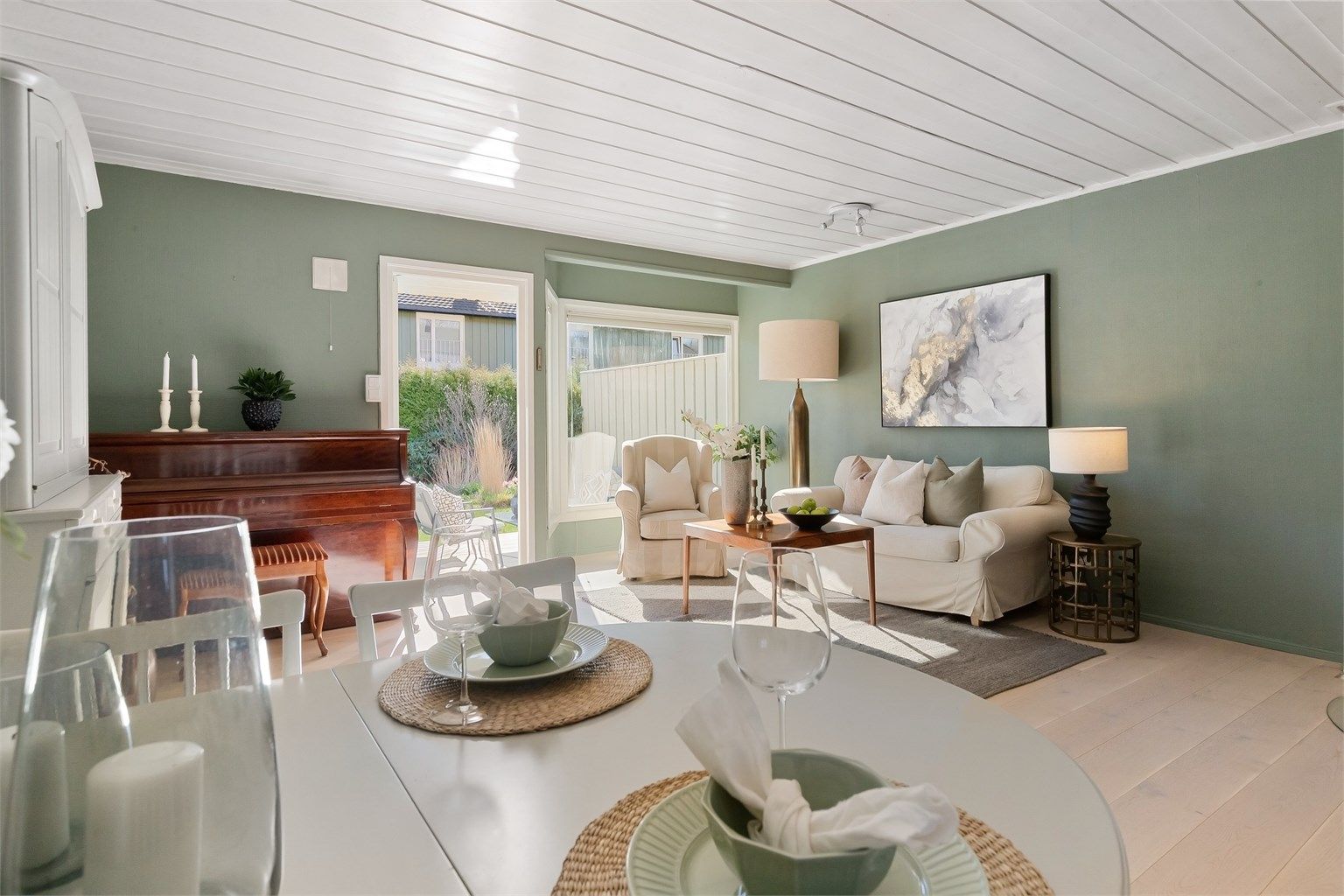 Rommet er lyst og luftig, med malte takplater som reflekterer dagslyset.