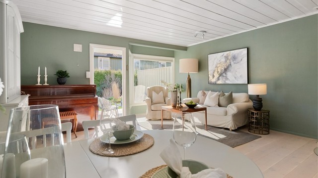 Rommet er lyst og luftig, med malte takplater som reflekterer dagslyset.