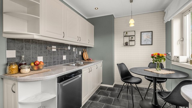 Kjøkkenet i hovedetasjen ligger naturlig tilbaketrukket fra stuen og har profilerte fronter, laminert benkeplate og godt med skap og benkeplass.
