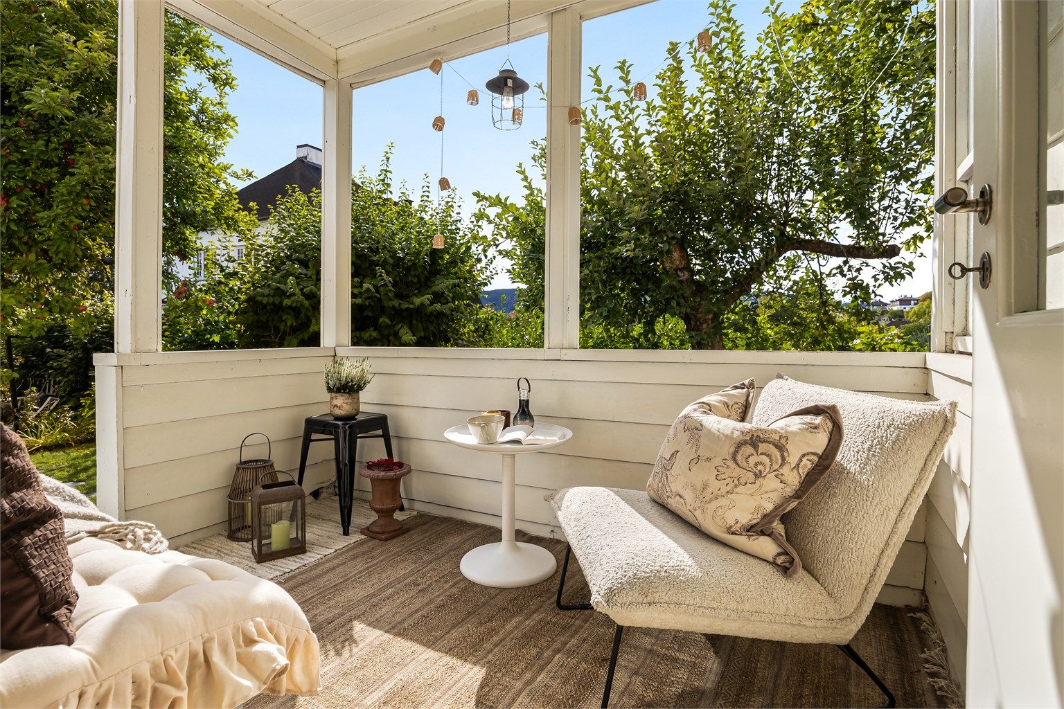 Overbygget sydvestvendt veranda på 6 kvm med god plass til sittegruppe og trapp ned til hagen.