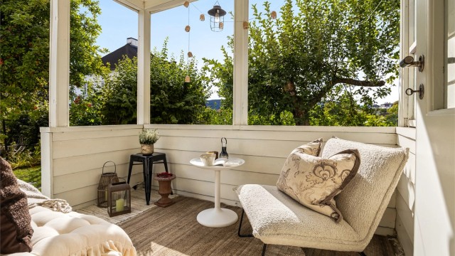 Overbygget sydvestvendt veranda på 6 kvm med god plass til sittegruppe og trapp ned til hagen.