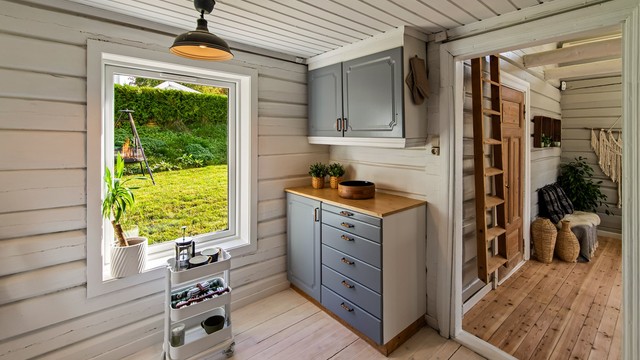 Lyst kjøkken med malte overflater og klassisk tregulv. Her er det også plass til et lite spisebord.