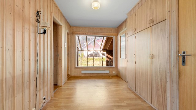 Lys og romslig hall i hovedetasjen med vindu ut mot overbygd balkong mot nordvest