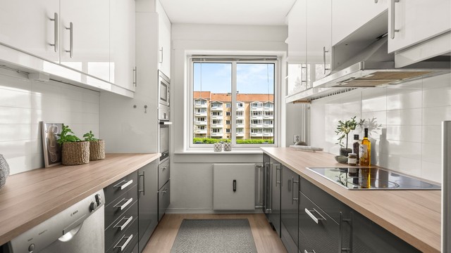Kjøkkenet har Ikea-innredning med glatte fronter og laminatbenkeplater som ble skiftet nylig i mai 2026