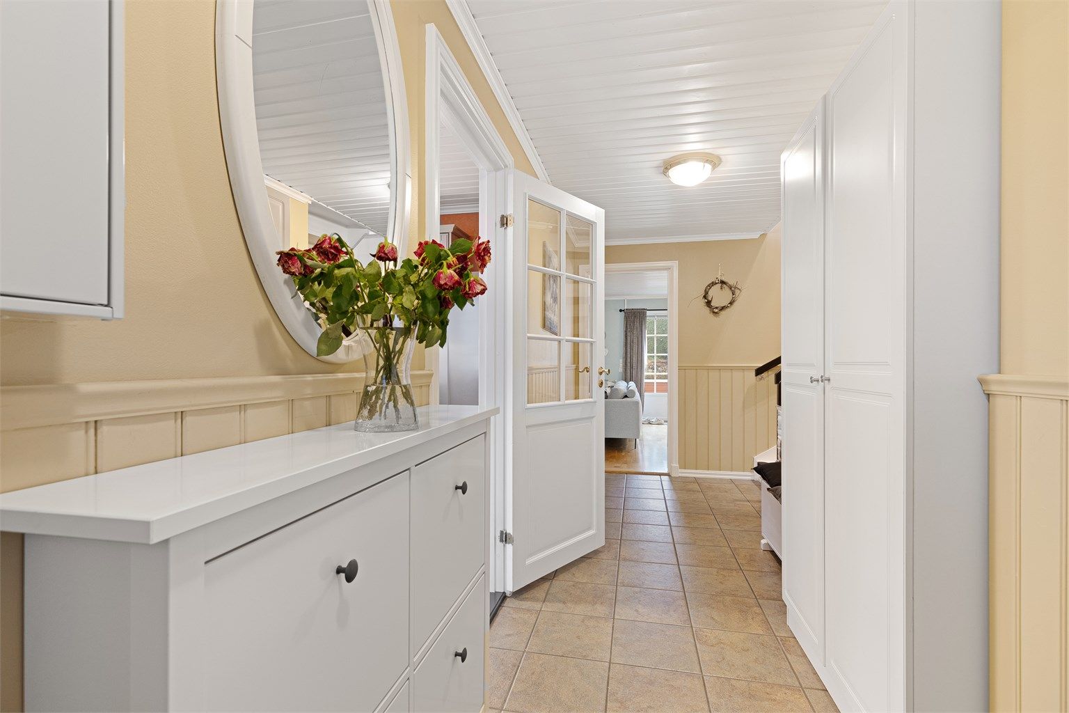 Velkommen inn i en romslig entré med flislagt gulv og gode lagringsmuligheter i bl.a garderobeskap.