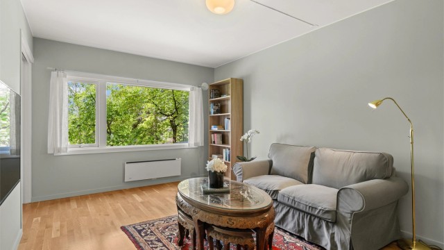Det store vestvendte vinduet gir rikelig med naturlig lys, og rommet har plass til både sofagruppe og spiseplass.