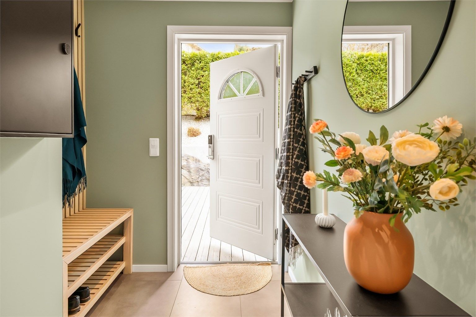 Hovedinngangen åpner direkte ut mot den store treterrassen, noe som skaper en fin flyt mellom inne- og uterom.