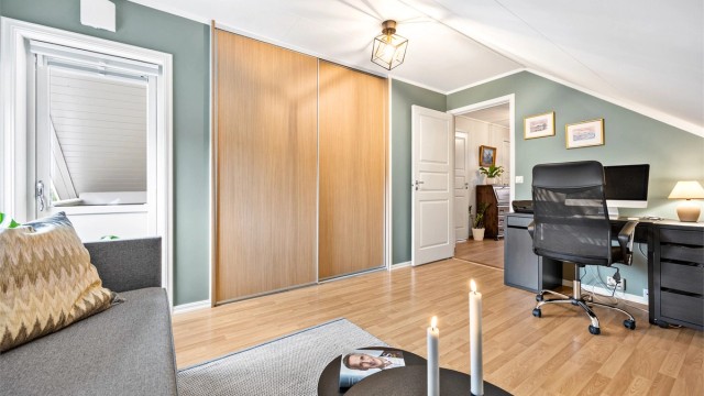 Rommet har skyvedørsgarderobe og utgang til boligens andre veranda.