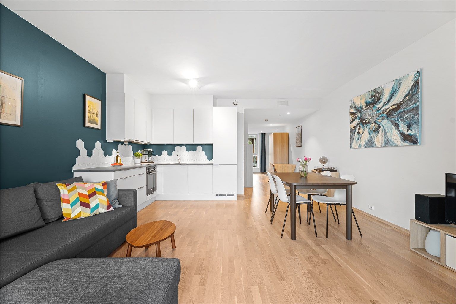 Leiligheten har en åpen kjøkken/stue løsning og har god plass til både sofagruppe med tv-seksjon samt spisegruppe. 