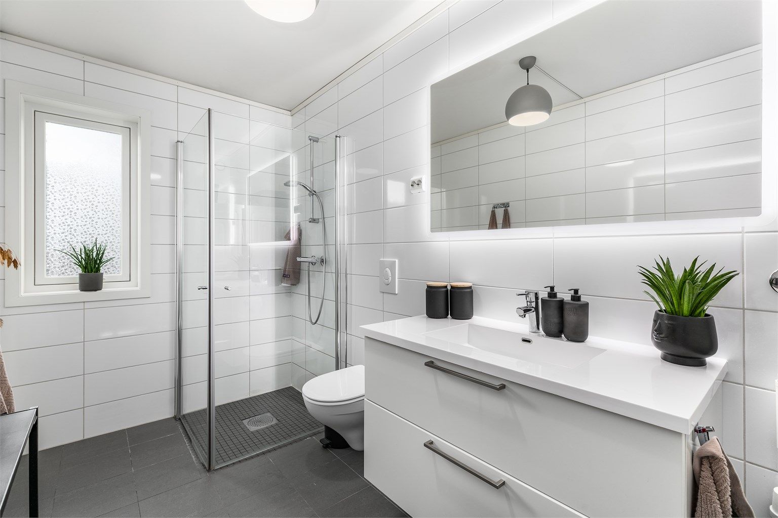 Badet er over 6 kvm. stort. Her er både gulv og vegger flislagt, i gulvet er det naturligvis også varme. Karmbelistninger er nymalt.