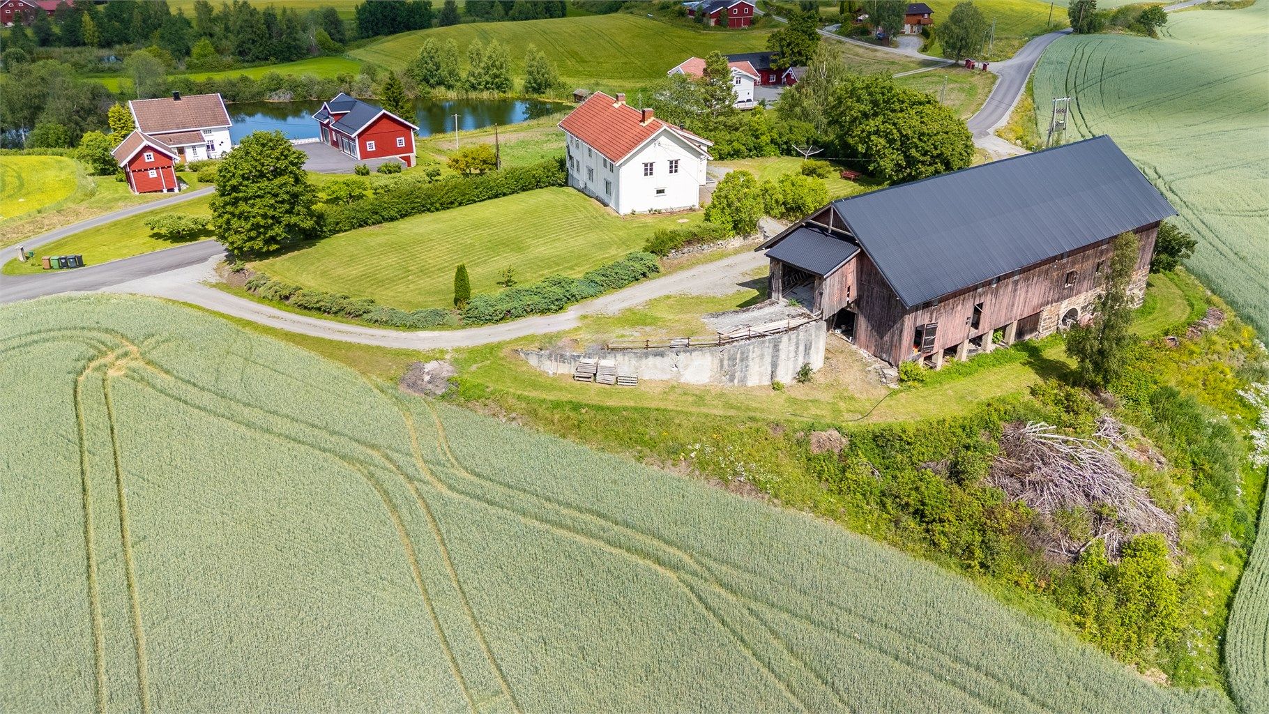Landlig og solrik beliggenhet med romslig tun og nydelig utsyn over nærområdet. Her får du en stor tomt med både våningshus og låve