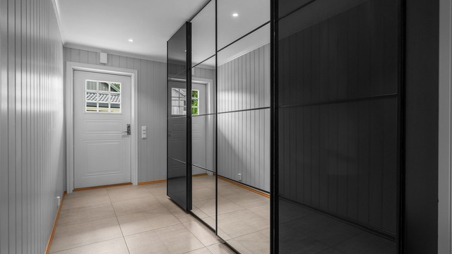 Romslig entré med stor skyvedørsgarderobe for rikelig med oppbevaring.