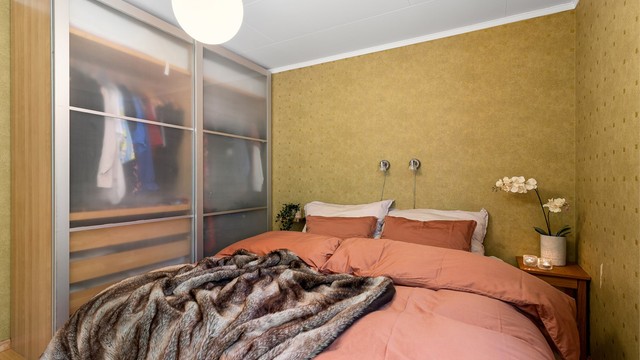 En stor skyvedørsgarderobe gir rikelig med oppbevaringsplass på soverommet.
