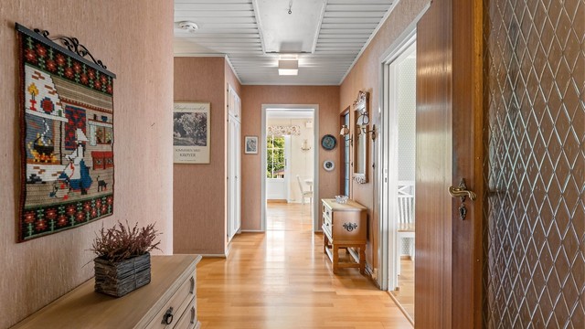 Gangen binder sammen rommene i første etasje og har parkett på gulvet.