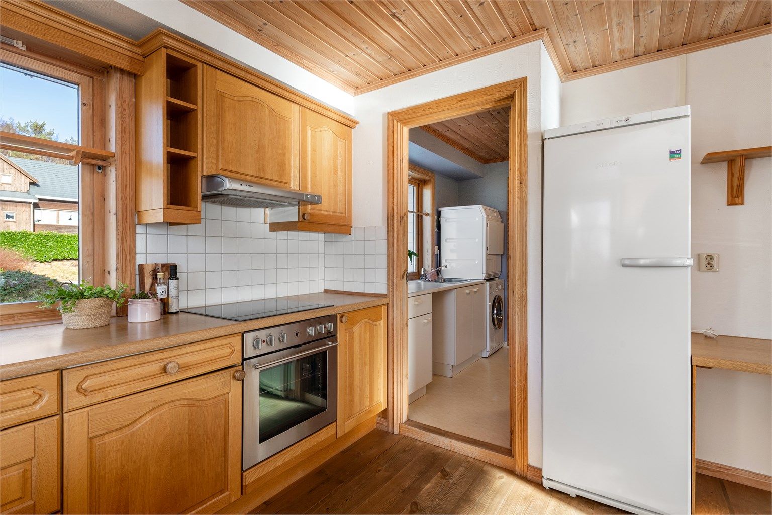 Fra kjøkkenet er det adkomst til vaskerom og videre adkomst til vindfang/entre