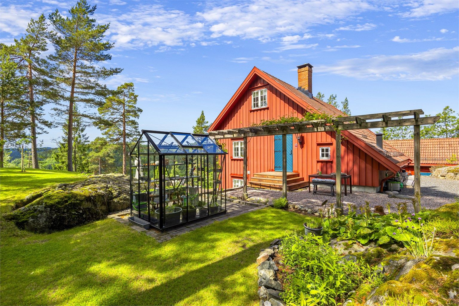 Tomten er pent opparbeidet med plenarealer og diverse beplantning/hage.