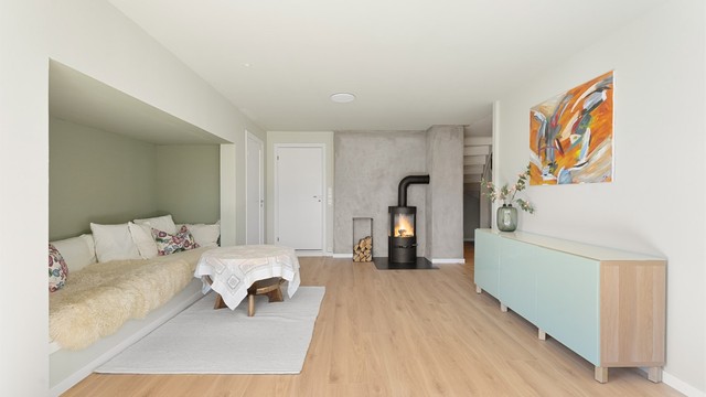 Et ildsted i kjellerstuen gir ekstra varme. Gulvet i kjelleren er avrettet og har fått nytt laminatgulv som en del av de senere års oppgraderinger.