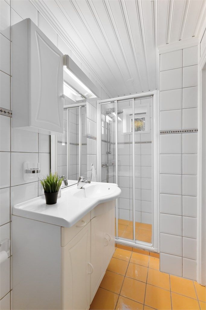 Boligens andre bad ligger i underetasjen og har dusjnisje med skyvedør.