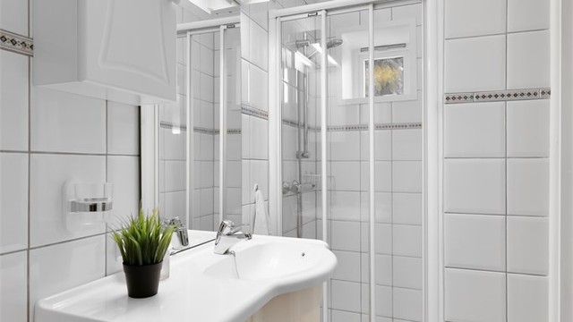 Boligens andre bad ligger i underetasjen og har dusjnisje med skyvedør.