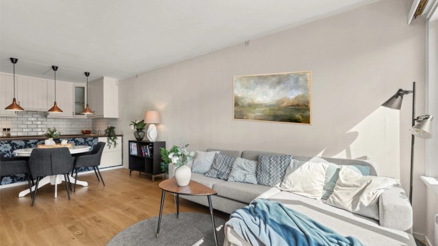 Et sosialt rom med stue, spisestue og kjøkken i åpen løsning.