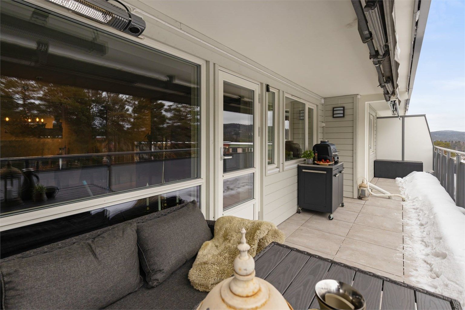 Balkongen har god plass til en utendørs sittegruppe for sosiale anledninger. Balkongdekket har fliser, noe som gir et solid og vedlikeholdsvennlig underlag.