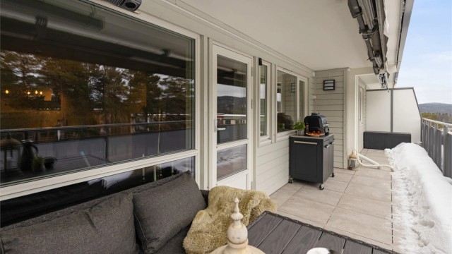 Balkongen har god plass til en utendørs sittegruppe for sosiale anledninger. Balkongdekket har fliser, noe som gir et solid og vedlikeholdsvennlig underlag.