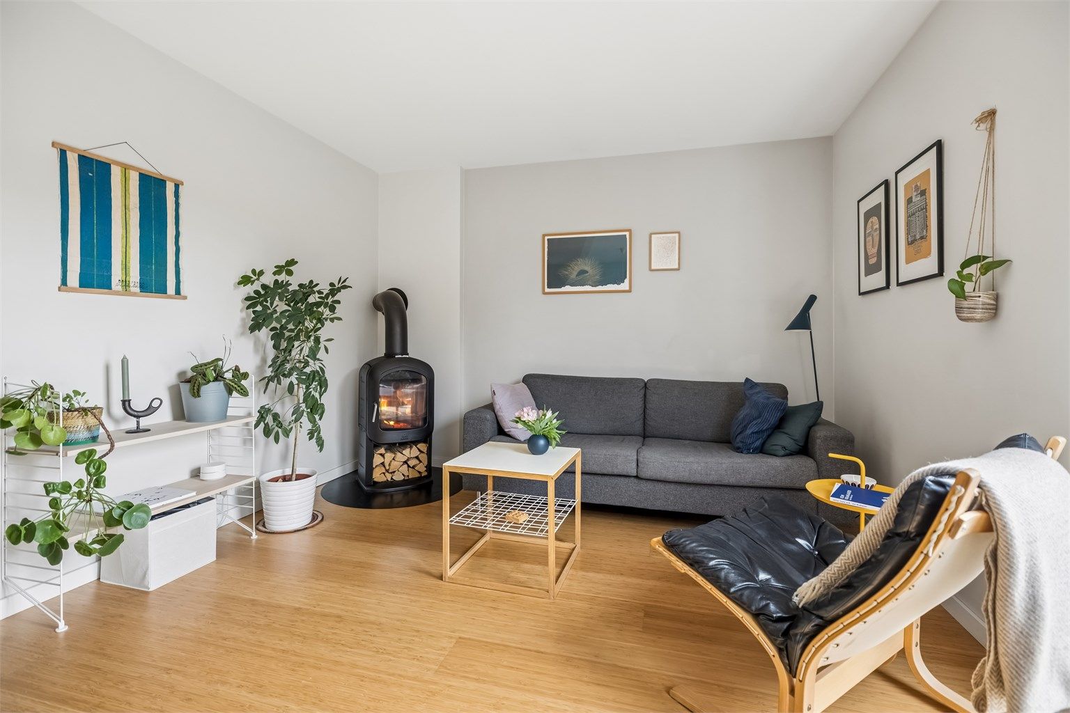 Stuen ligger lunt til i hjørnet av rommet, med god plass til sofakrok og TV. Peisen i hjørnet tilfører både varme og atmosfære. 