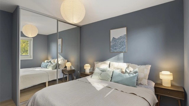 Rommet er innredet med en romslig skyvedørsgarderobe med speilfronter.