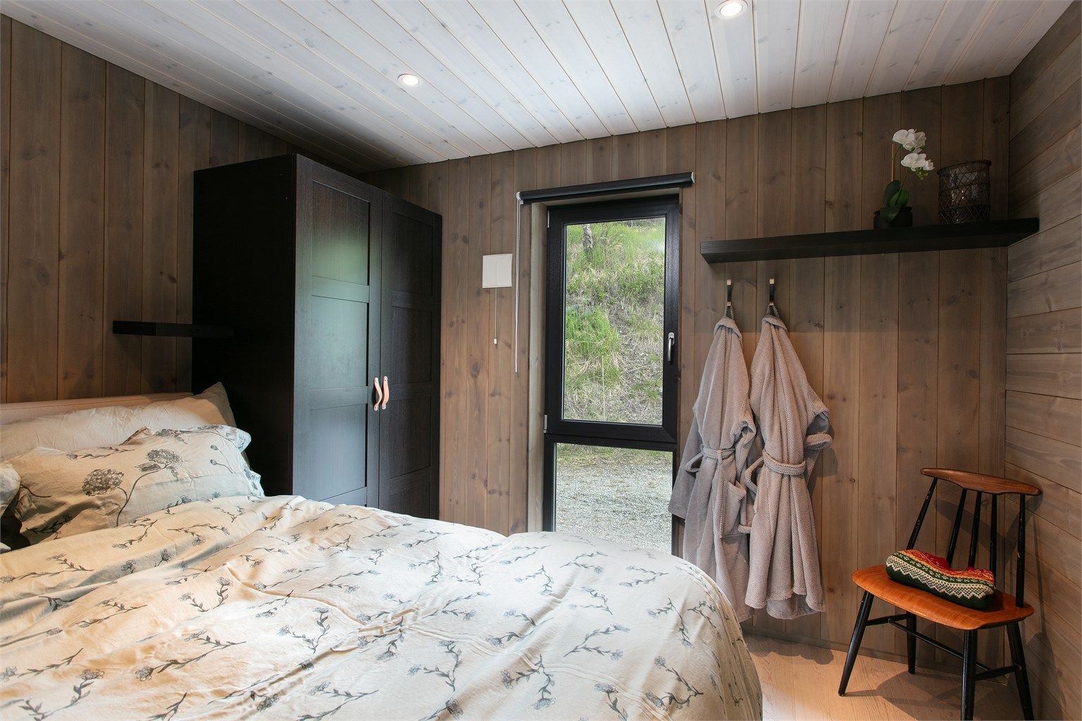 Soverommet har god plass til dobbeltseng og store vindusflater mot terrenget utenfor.