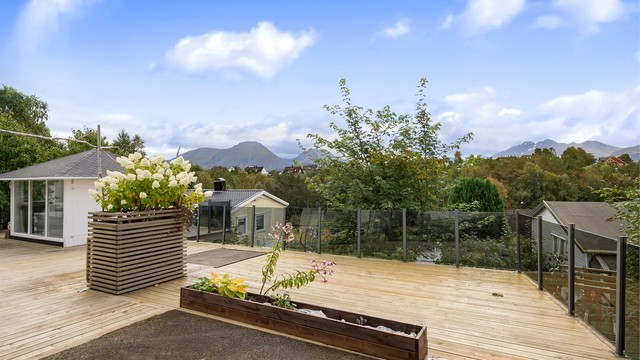 Stor terrasse på terreng mot syd med glassrekkverk