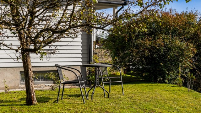 I hagen er det plass til en hyggelig sittegruppe under trærne.