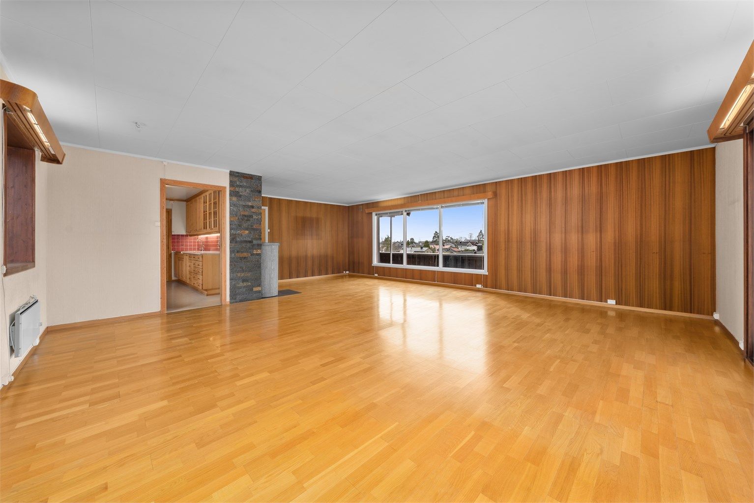 Rommet har en åpen forbindelse mot kjøkkenet, noe som skaper en sosial sone.