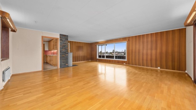 Rommet har en åpen forbindelse mot kjøkkenet, noe som skaper en sosial sone.