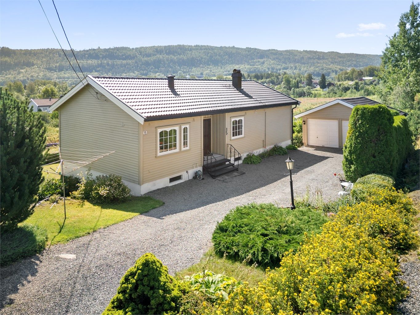 Enebolig med dobbel garasje. God plass for parkering i gruset gårdsplass