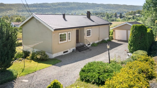 Enebolig med dobbel garasje. God plass for parkering i gruset gårdsplass