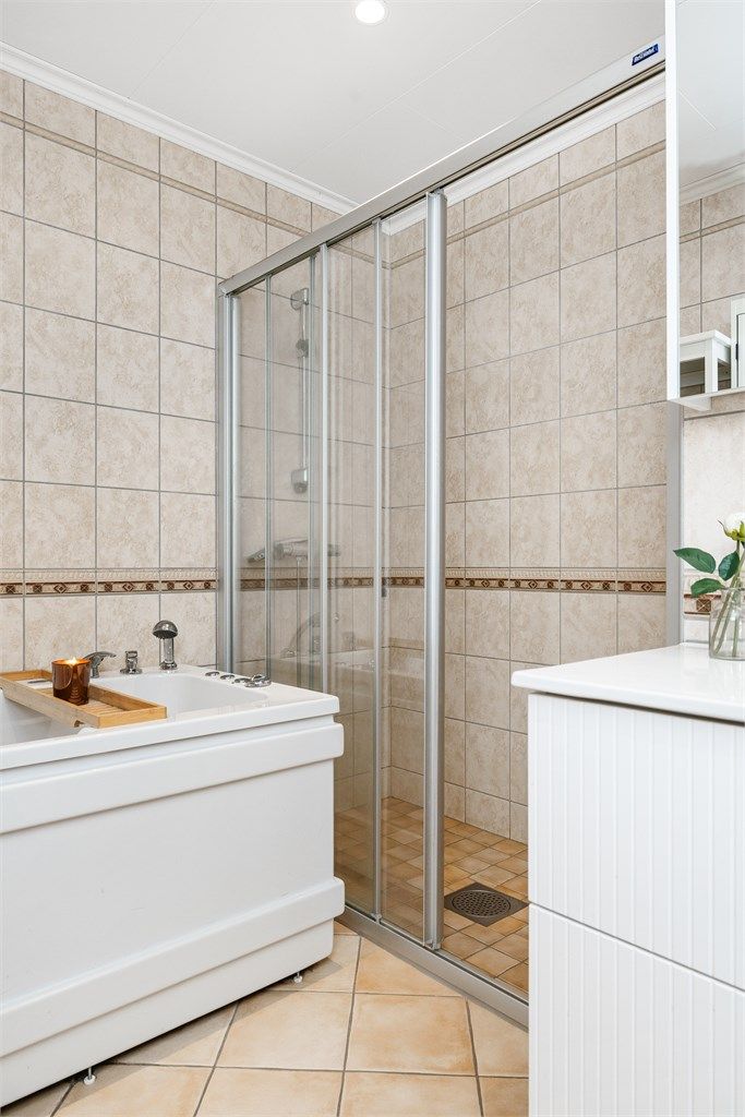 Dusjnisjen har skyvefelt i glass, og badet har også et boblebadekar for ekstra komfort