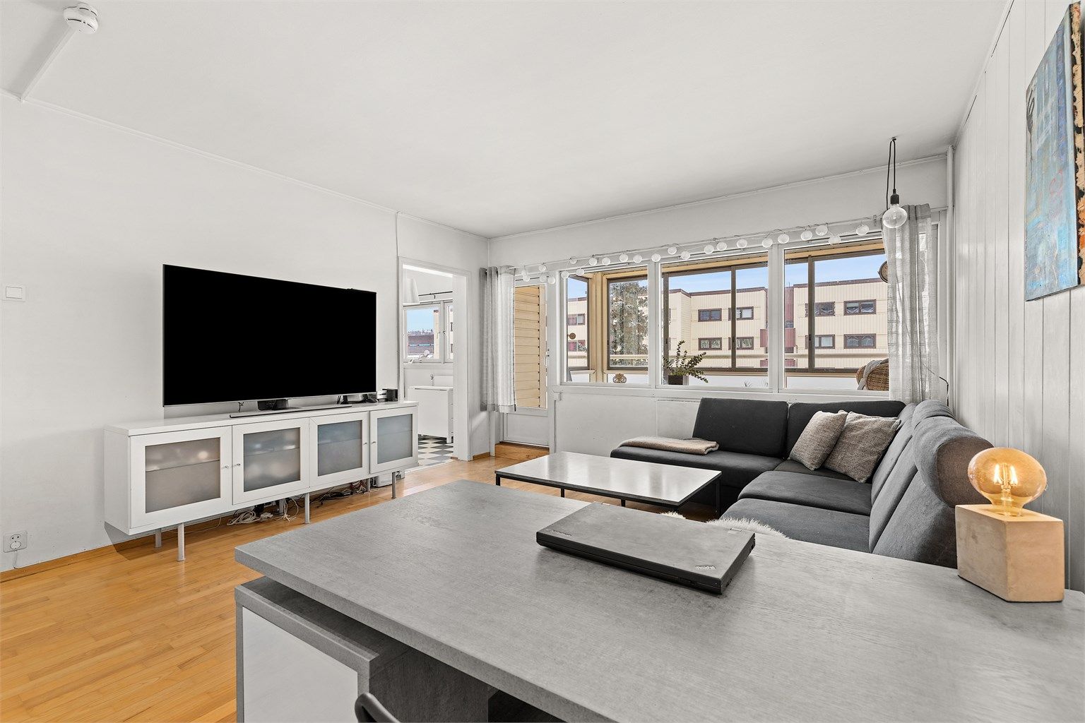 Lys og romslig stue med store vindusflater som slipper inn rikelig med dagslys