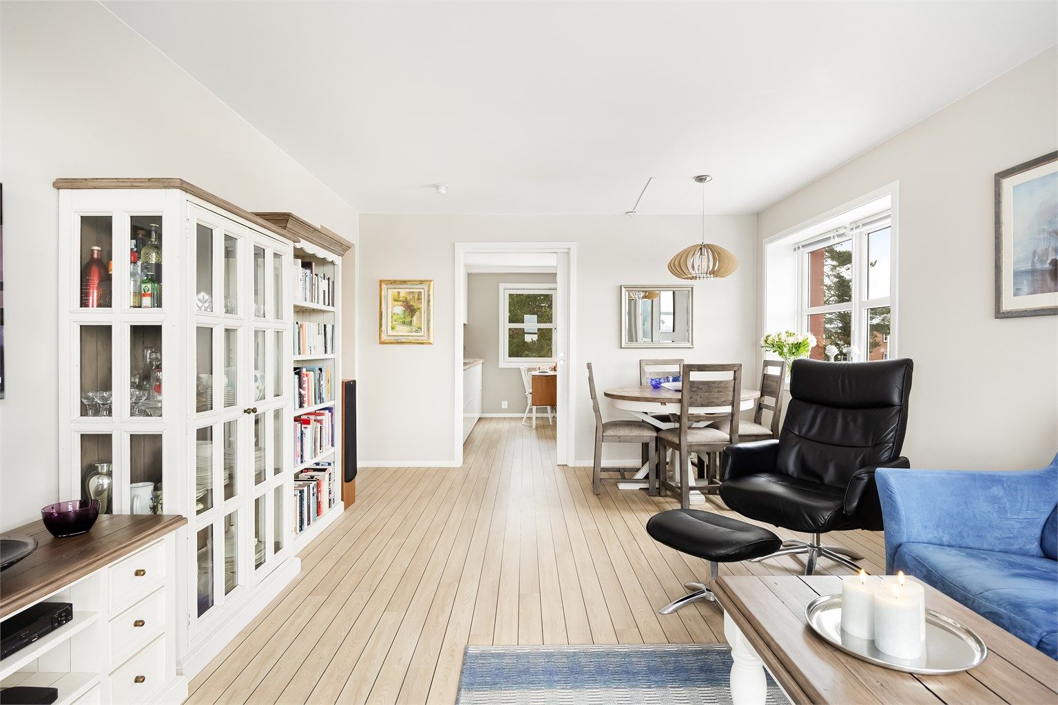 Stuen fremstår moderne med lyse overflater og gjennomgående gulv.