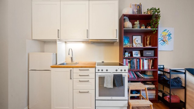 Her finner du et funksjonelt kjøkken med hvite, glatte fronter og benkeplate i heltre med kontaktplast.