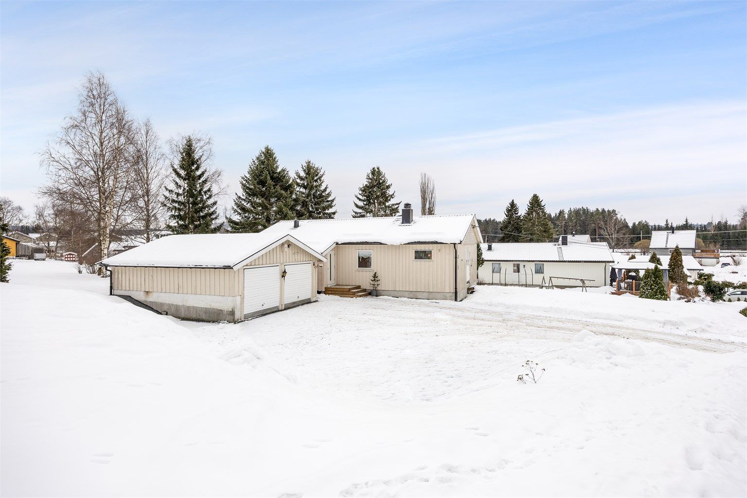 Eiendommen ligger høyt og luftig til i et etablert boligområde med landlig preg.