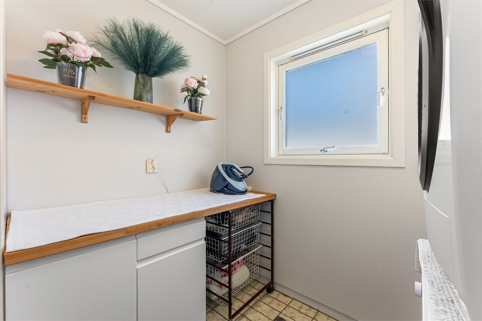 Vaskerom med fliser på gulv med gulvvarme, malte vegger, takplater i himling, baderomsmøbel, vegghengt høyskap og opplegg for vaskemaskin